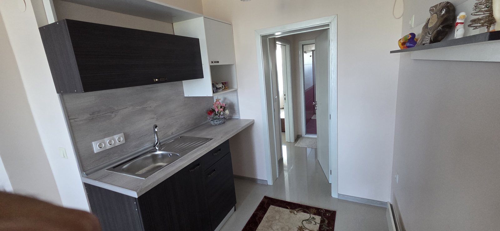 Photo 007 · Compact kitchen and adjoining bathroom doorway